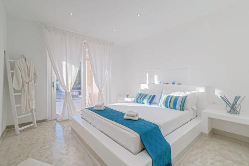 een witte slaapkamer met een groot wit bed en een raam bij Villa Niraclò by Raro Villas in Carovigno