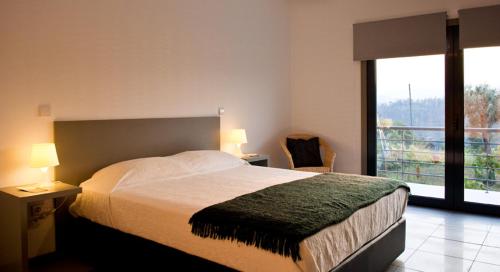 a bedroom with a large bed and a large window at Casa de Vila Cete in Alpendurada
