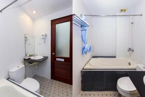 uma casa de banho com uma banheira, um WC e um lavatório. em Little Hanoi Hostel em Hanói