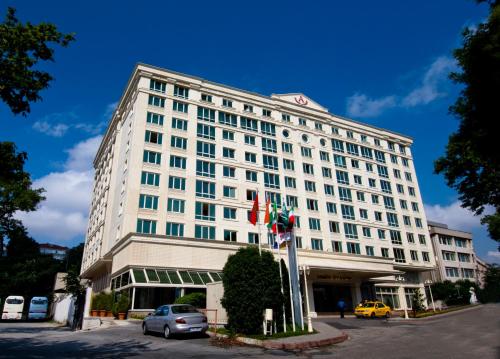 um grande edifício branco com carros estacionados em frente em Akgun Istanbul Hotel em Istambul