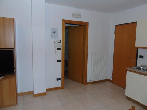 an empty room with a door and a kitchen at Magic Riva Apartment in Riva del Garda