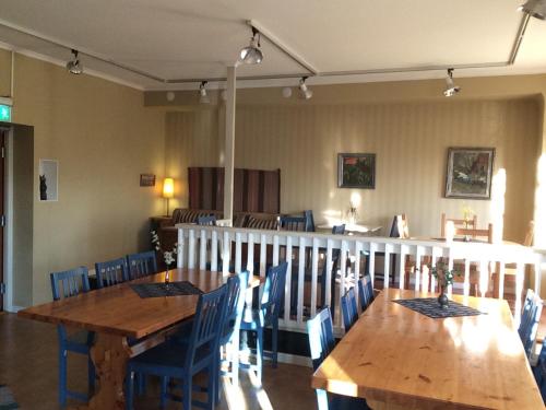 une salle à manger avec des tables en bois et des chaises bleues dans l'établissement Örnsköldsviks Vandrarhem, à Örnsköldsvik