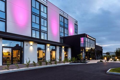 um edifício com luzes cor-de-rosa na lateral em Best Western Plus Europe Hôtel Brest em Brest
