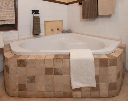a bathroom with a tub with a towel on it at Aloe Guest House in Hermanus