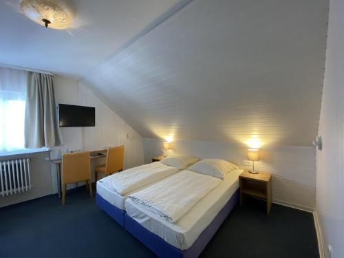 a bedroom with a bed and a table and a desk at Römerhof in Stuttgart