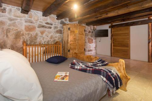 a bed in a room with a stone wall at Stonehouse Marina in Vrsine