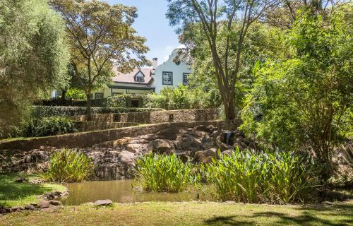 a house with a pond in front of a garden at Karen Gables in Nairobi