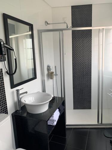 a bathroom with a sink and a large mirror at Fonte Luminosa in Lisbon