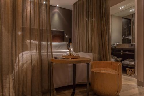 sypialnia z łóżkiem, stołem i krzesłem w obiekcie Hidden Hotel w Paryżu