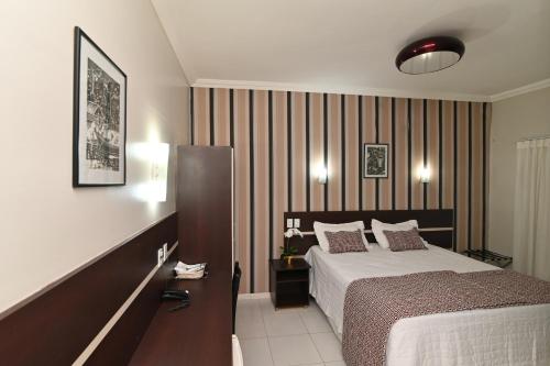 um quarto de hotel com uma cama e uma secretária com uma cama sidx sidx sidx em Hotel São Bento em Marabá