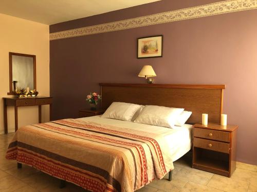 1 dormitorio con 1 cama grande y 2 mesitas de noche en Sufara Hotel Suites, en Amán