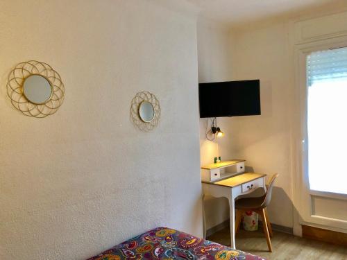 1 dormitorio con cama y escritorio con espejo en Hôtel Colisée-Verdun Centre Gare Saint-Roch, en Montpellier