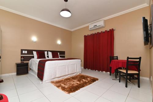 a bedroom with a bed and a red curtain at Hotel São Bento in Marabá