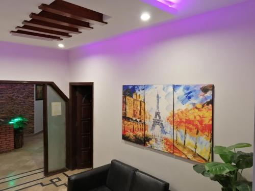 a living room with a painting of the eiffel tower at Seaview Lodge Guest House in Karachi