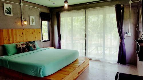a bedroom with a large bed and a large window at Home No.9 in Ko Lanta