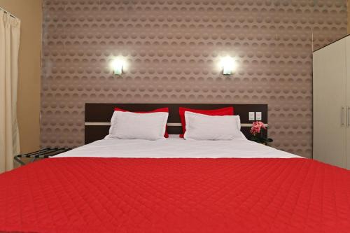 a bedroom with a red bed with two pillows at Hotel São Bento in Marabá
