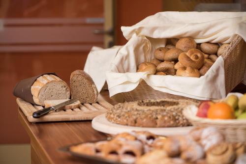 a table topped with baskets of bread and other foods at JUFA Hotel Graz City in Graz