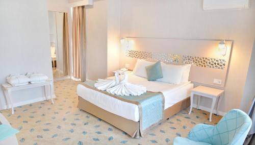une chambre d'hôtel avec un lit et une chaise dans l'établissement ADEMPİRA TERMAL&SPAHOTEL, à Denizli