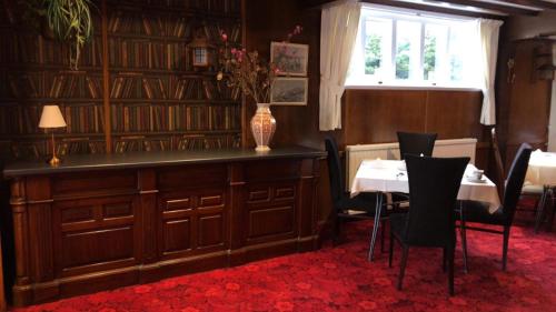 a dining room with a table and a vase of flowers at Gable End Hotel in Great Yarmouth