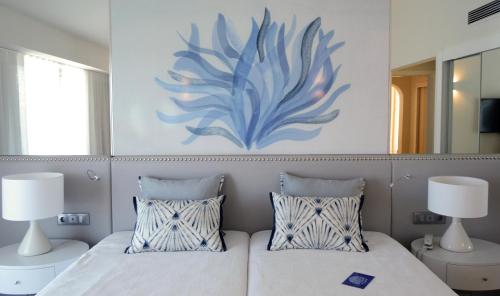 a bedroom with two beds and a painting on the wall at Quinta do Lago Country Club in Quinta do Lago