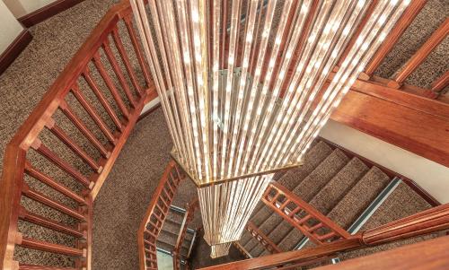 a wooden spiral staircase with a large chandelier at Coppid Beech in Bracknell