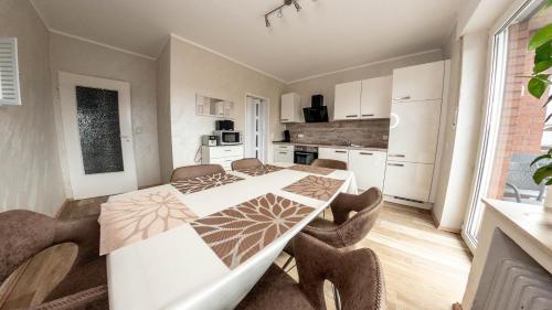 eine Küche und ein Esszimmer mit einem Tisch und Stühlen in der Unterkunft Willma Apartmenthaus in Beelen
