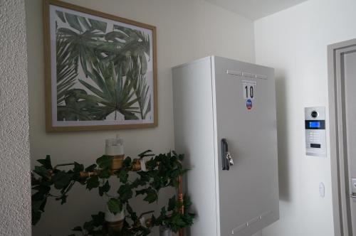a white refrigerator in a room with a plant next to it at U201 Brunswick Living Top floor Balcony Close to APT and CBD Free Wifi Tram at Doorstep in Melbourne
