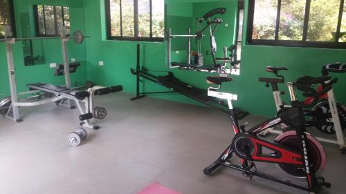 a gym with several exercise equipment in a green wall at White Castle Hotel Arua in Gulu