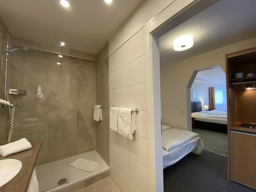 a bathroom with a shower and a sink and a mirror at Kulinarium an der Glems in Stuttgart