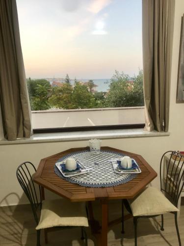 a table and chairs with a view of a window at B&B Magna Grecia in Crotone
