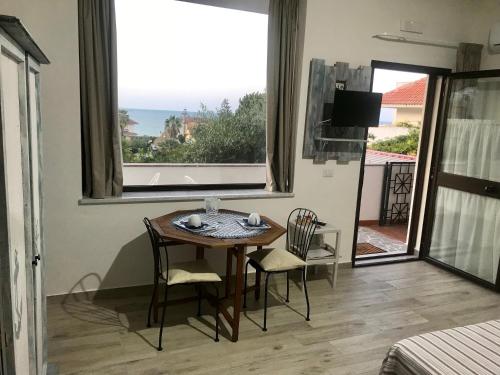 comedor con mesa, sillas y ventana en B&B Magna Grecia, en Crotone