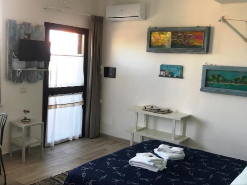 a room with a bed and a television and a window at B&B Magna Grecia in Crotone