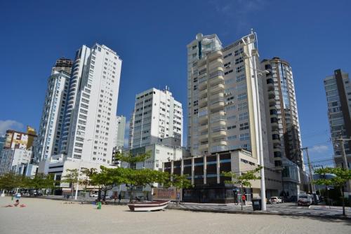 een groep hoge gebouwen in een stad bij FRENTE MAR PÉ NA AREIA, na Av Atlântica in Balneário Camboriú