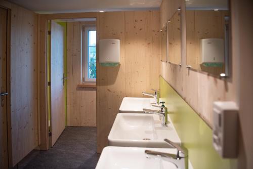 Ganterschwil的住宿－Restaurant und Kaeserei Berghof，浴室里一排三个水槽