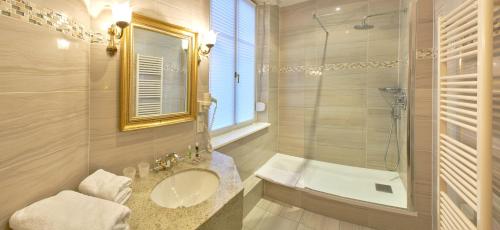 a bathroom with a sink and a shower at Hotel Restaurant Du Parc in Thann