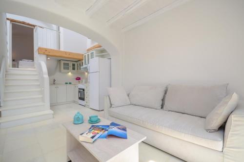 a white living room with a couch and a table at Naxian Queen Luxury Villas & Suites in Agia Anna Naxos