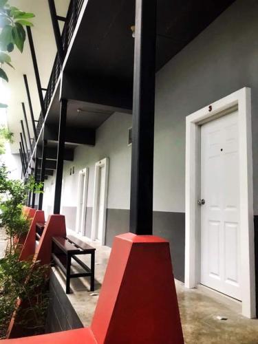 a row of red benches next to a white door at บ้านพระจันทร์ รีสอร์ท in Ban Khok Sawang (1)