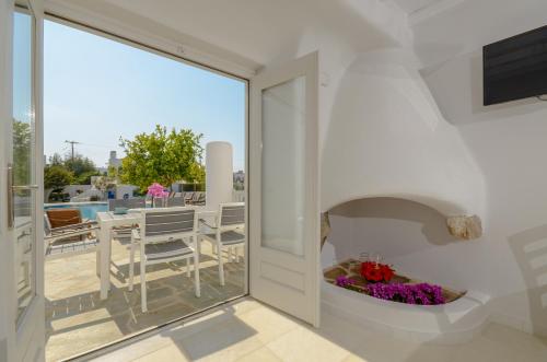 a room with a balcony with a fireplace at Naxian Queen Luxury Villas & Suites in Agia Anna Naxos