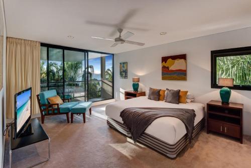 - une chambre avec un lit et une télévision à écran plat dans l'établissement Waves 3 Luxury 3 Bedroom Endless Ocean Views Central Location + Buggy, à Île Hamilton