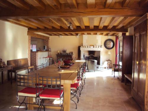 une salle à manger avec une grande table et des chaises en bois dans l'établissement La Halte de Chambord, à Mur-de-Sologne