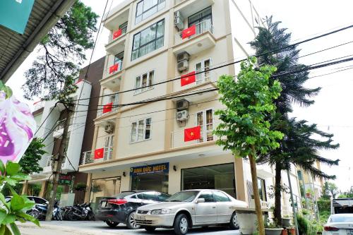 a tall building with cars parked in front of it at Anh Duc Hotel in Tam Ðảo