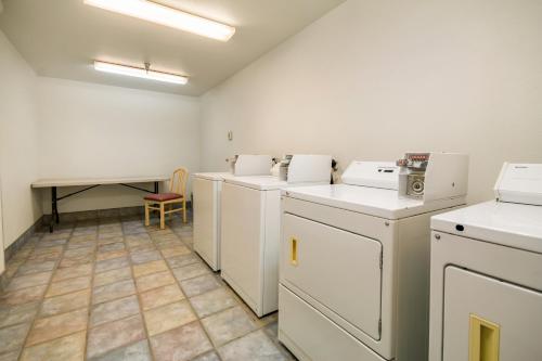 lavadero con electrodomésticos blancos y mesa en Motel 6-Lemoore, CA, en Lemoore