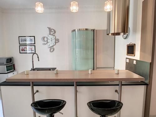 une cuisine avec deux tabourets noirs à un comptoir dans l'établissement Nestor&Jeeves - DALPOZZO GRANDE - Central - Close beaches, à Nice