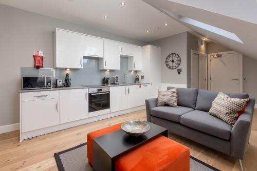 a living room with a couch and a kitchen at Destiny Scotland Hanover Apartments in Edinburgh
