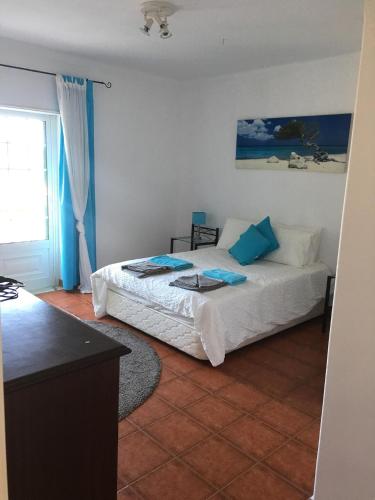a bedroom with a bed and a table in it at Quinta Turki Malika in Óbidos
