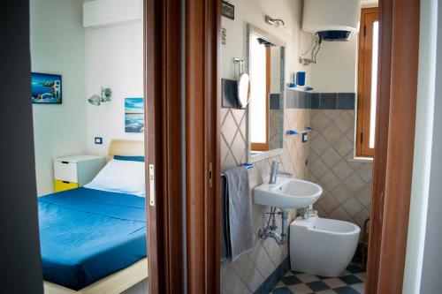 a small bathroom with a sink and a bed at Beach House Acquamarina in Letojanni