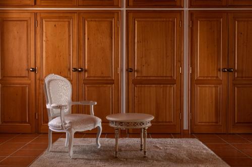 a chair and a stool in a room with wooden cabinets at A Casinha in Vila Nova de Famalicão