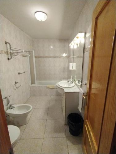 a bathroom with a sink and a toilet and a shower at Apartamentos Rascafria Cerquilla in Rascafría