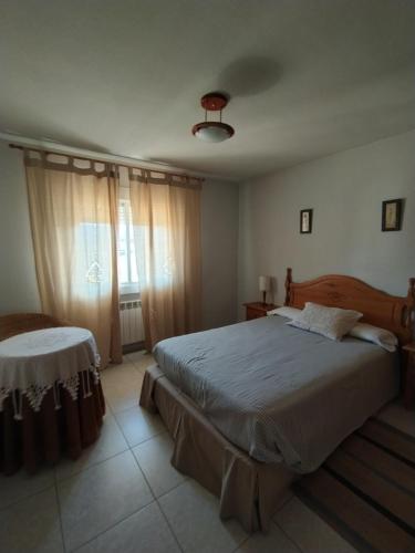 Un dormitorio con una cama grande y una ventana en Apartamentos Rascafria Cerquilla en Rascafría