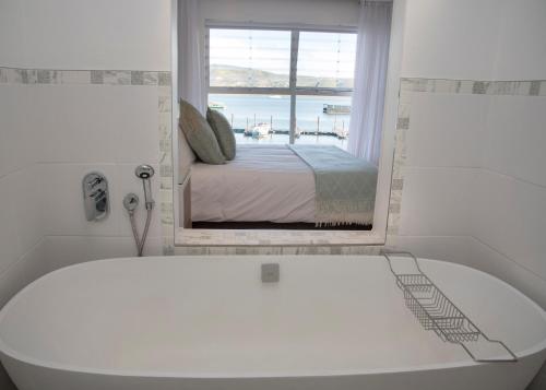 41 Laguna Grove في كنيسنا: حمام مع حوض استحمام ونافذة مع سرير
